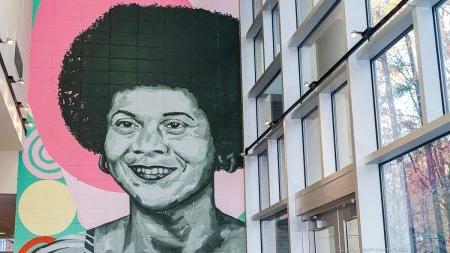 Large painted mural of Sonja Haynes Stone on a wall inside the Sonja Haynes Stone Center for Research in Black Culture and History on the campus of U.N.C. Chapel Hill.